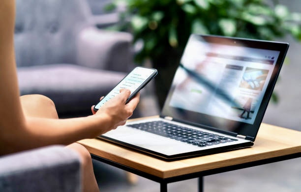 Wireless wifi for remote work in airport lounge bar, hotel lobby or cafe. Phone and laptop. Woman using smartphone and modern notebook pc computer on table. Real estate agent or student reading email.